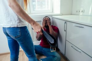 domestic violence. angry girl hitting african american man at kitchen